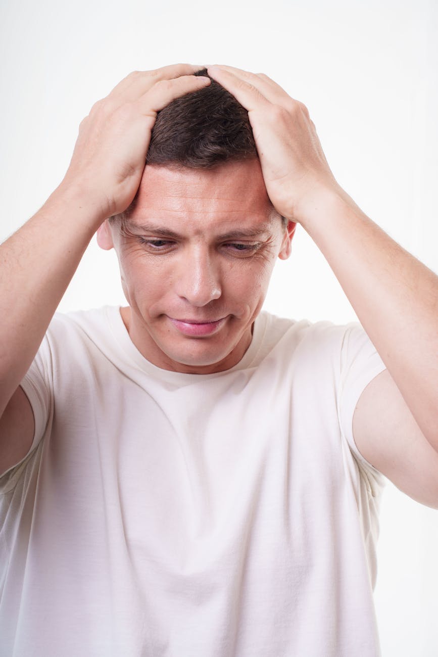 A person sitting alone looking anxious and lost in thought, representing the experience of health anxiety