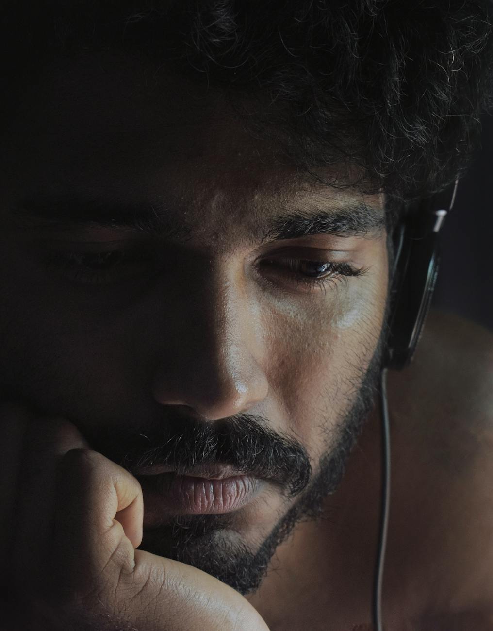 Man with headphones looking stressed and anxious
