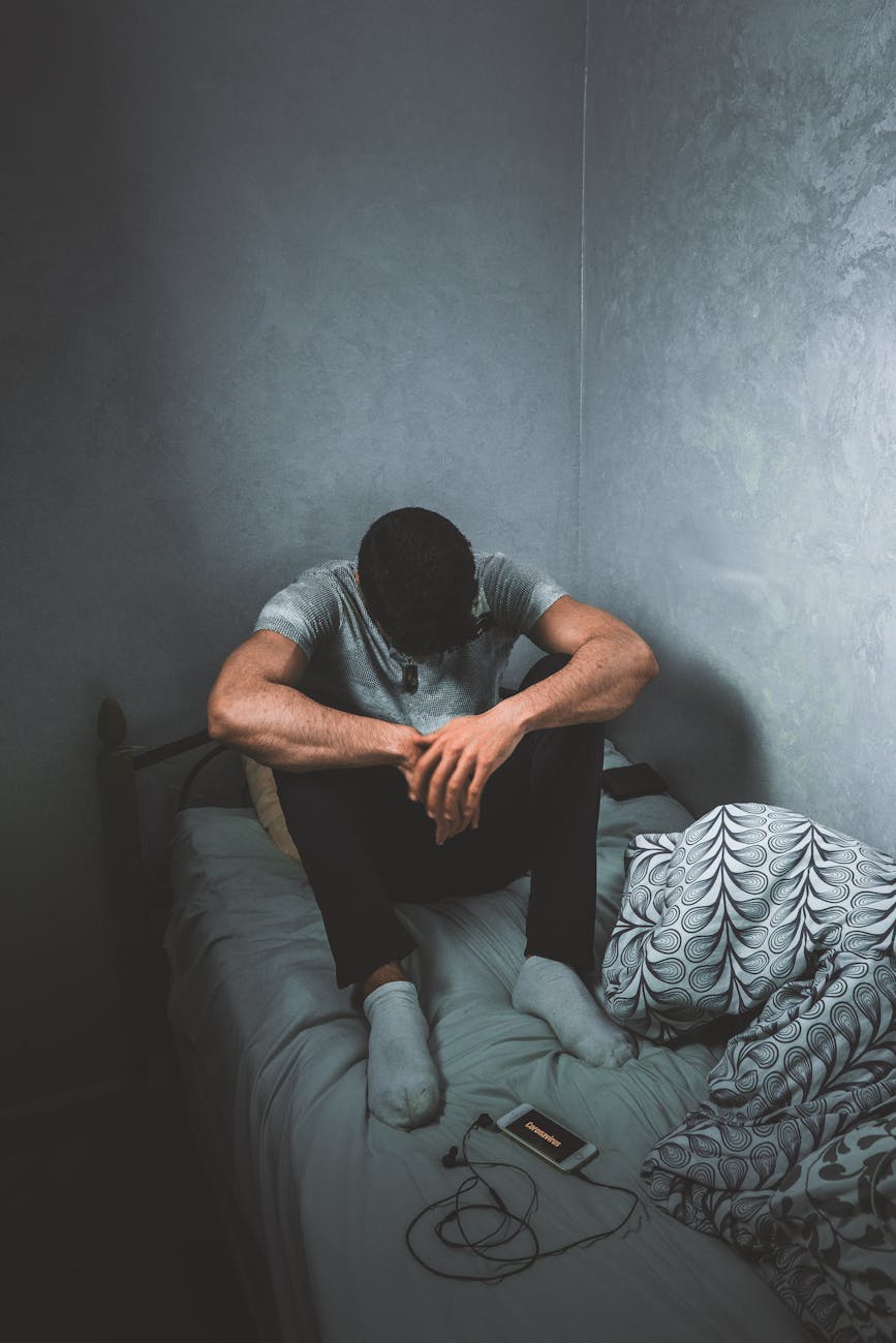 A person sitting alone in a dimly lit room, head in hands, reflecting the inner weight of anxiety